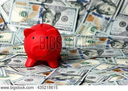 A Red Piggy Bank And Background Dollars
