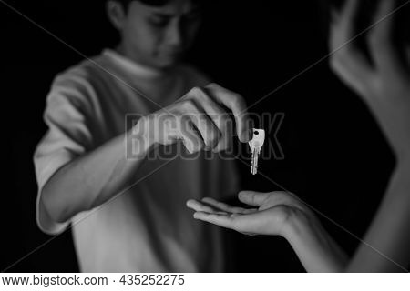 A Man Handing Over A Key While Crying