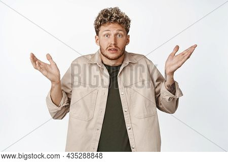Confused Young Blond Man Shrugging Shoulders And Raise Hands Up, Dont Know, Being Clueless, Have Not