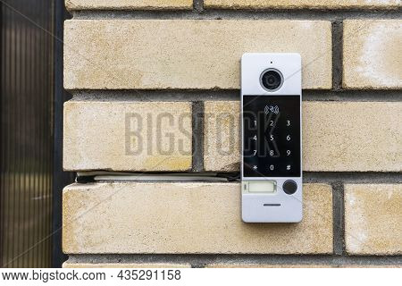 An Intercom On The Door Of A Private House, An Intercom Panel With A Video Camera On A Brick Beige F
