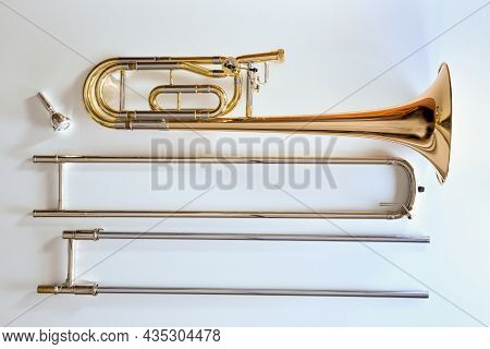 Trombone With Transposer Disassembled On A White Table. Top View. Horizontal Composition.
