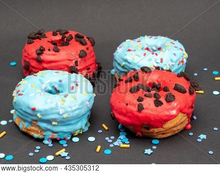 Red And Blue Cronuts On A Black Background. High Quality Photo