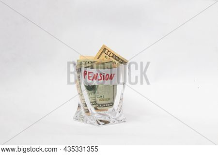 A Pile Of Dollars In A Whiskey Glass On A White Isolated Background. Retirement Savings In Dollars. 