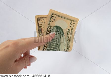 10 Dollars In The Hand Close-up On A White Isolated Background. A Ten-dollar Bill