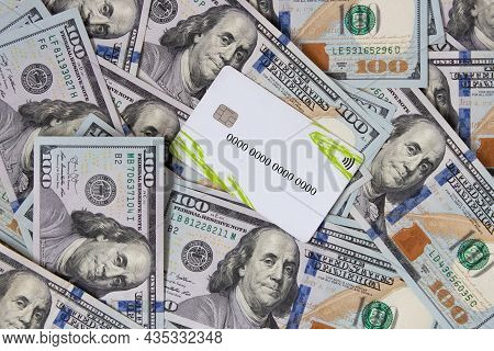 A Bunch Of Dollars And A Bank Card Close-up. The Background Is Made Of Dollars. Payment By Plastic C