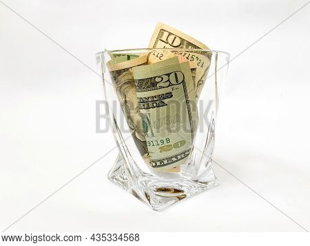 A Pile Of Dollars In A Whiskey Glass On A White Isolated Background. Retirement Savings In Dollars. 