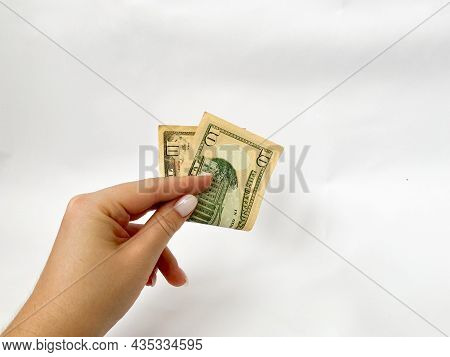 10 Dollars In The Hand Close-up On A White Isolated Background. A Ten-dollar Bill