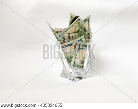 A Pile Of Dollars In A Whiskey Glass On A White Isolated Background. Retirement Savings In Dollars. 