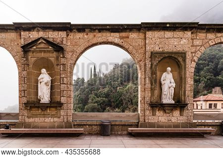 Arch Of Montserrat Monastery In Foggy Winter Day. Hiking Religious Destination.