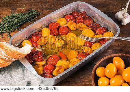 Ready-made Tomato Confit With Garlic, Hot Pepper And Thyme In Olive Oil On A Baking Sheet On The Tab
