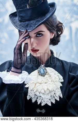 19th century women's hairstyle, makeup and costume. Portrait of a beautiful brunette lady in authentic 19th century style. Historical reconstruction.