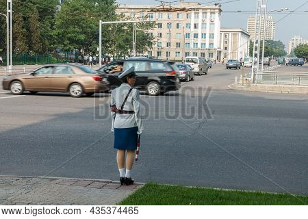 Pyongyang, North Korea - July 29, 2014: A Girl Policeman Regulates Traffic At A Crossroads In Pyongy