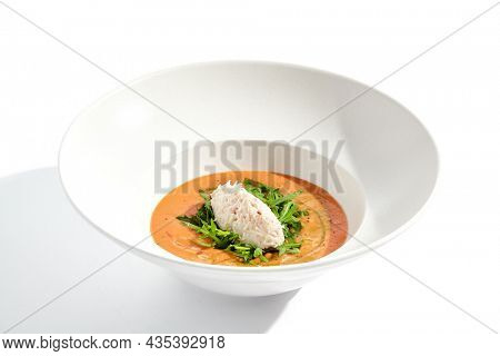 Summer Spanish soup gazpacho with crab meat and rucola isolated on white background. Delicious cold tomato soup with crab. Clean eating for diet.Healthy food in restaurant menu. Crab gazpacho