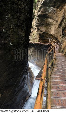 Wooden Walkpath As Bridge Over Cascading Waterfall
