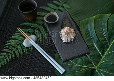 Temaki Tuna Sushi On Restaurant Table Served On Black Tray With Soy Sauce And Chopsticks. Palm Branc