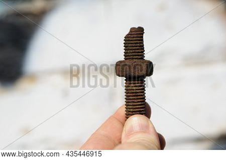 Old Rusty Bolt, Iron Rod With Screw Threads, In Hand. Rusted Mechanical Components. Holding Threaded