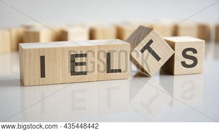 Wooden Cubes With The Letters Ielts On The Bright Surface Of A Gray Table, Business Concept.