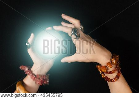 Fortune Teller Or Witch Hands And A Glowing Magic Ball Isolated On Black Background. Halloween, Magi
