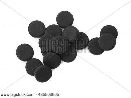 Activated Charcoal Pills On White Background, Top View. Potent Sorbent