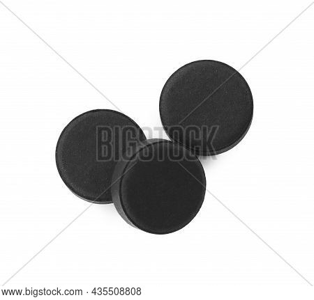 Activated Charcoal Pills On White Background, Top View. Potent Sorbent