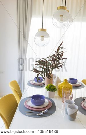 Yellow Chair And Table With Pink Pastel Plate Setting On Dinning Table.