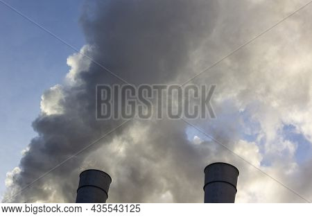 Air Pollution By Smoke Coming Out Of Two Factory Chimneys. Close-up From Below Of Smoke Coming Out O