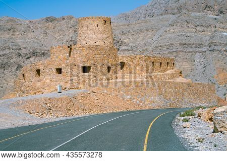 Stone Walls Of Small Medieval Arabian Fort Under Tall Mountain Cliffs. Fortress In Bukha, Musandam P