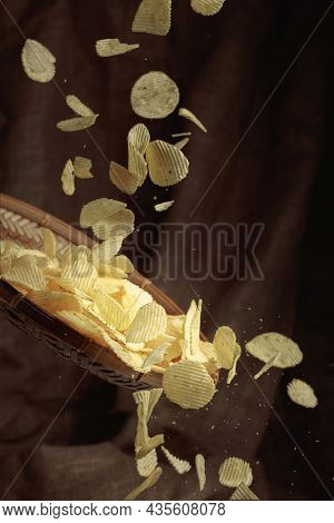 Falling Potato Chips On The Background Of Burlap. Copy Space.