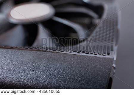 Detail of a new high end graphics card computer hardware upgrade on a desk. Edge of the cooling system