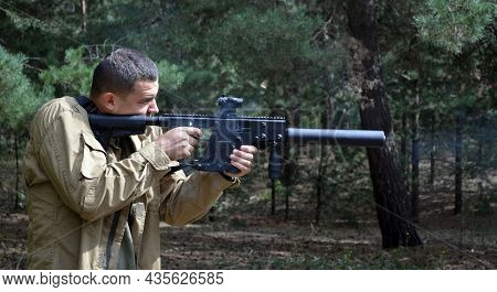 Man with KRISS Vector 9*21 caliber submachine gun in the forest. Unformal shooting range near Kiev. September 6,2021. Kiev Region, Ukraine