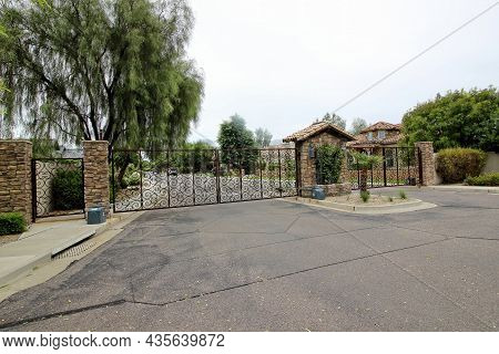 Ornate Metal Entrance And Exit Gates With Stone Columns