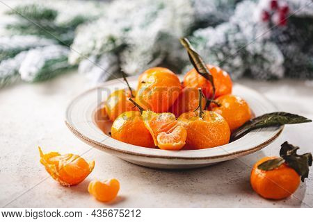 Fresh Mandarin Fruit Or Tangerines With Leaves In A Bowl On White Background With Winter Decorations