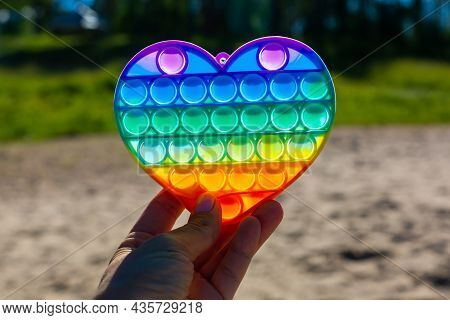 Colorful Antistress Sensory Toy. Pop It Kids Game In Hand. Outdoor Games For Children. Bright Multi-