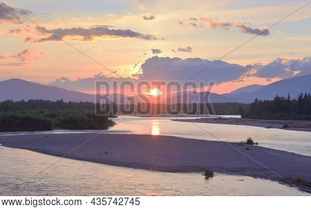 The River Bank In The Altai Mountains Under The Golden Evening Sky. Siberia, Russia