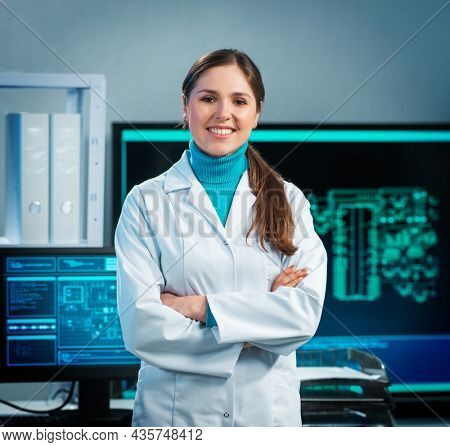 Workplace of young woman in modern microelectronics manufacturing lab. Engineer works in a modern scientific laboratory on computing systems and microprocessors.