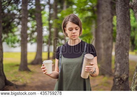 Portrait Of Happy Smiling Young Woman Comparing Thermo Cup Or Tumbler With Disposable Paper Coffee C