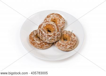 Spice Cookies In The Form Of Rings Glazed With Icing Sugar On A White Dish On A White Background