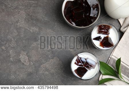 Glasses Of Milk With Delicious Grass Jelly On Grey Table, Flat Lay. Space For Text