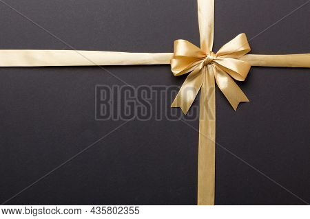 Top View Of Gold Ribbon Rolled And Yellowbow Isolated On Colored Background. Flat Lay With Copy Spac