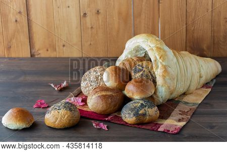 Straight On View Of A Homemade Bread Cornucopia With Rolls Spilling Out.