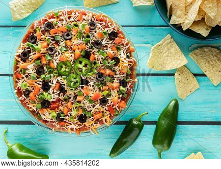 Top Down View Of A Homemade 7 Layer Dip With Tortilla Chips Ready For Serving.