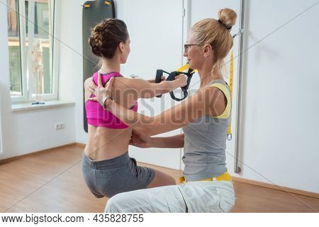 Woman using sling trainer during physical therapy