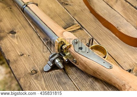 Shutter And Trigger Part Of The Old Weapon Close-up On A Wooden Table