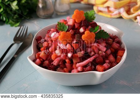 Salad Vinaigrette With Beets, Potatoes, Carrots, Squid, Pickles And Vegetable Oil On Blue Background