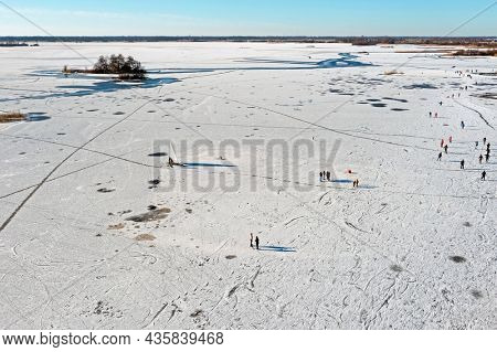 Aerial from ice sailing and ice skating on a frozen lake in the Netherlands