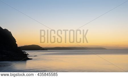 Beautiful Sunrise Over Pentewan Sands In Cornwall With Pastel Sky And Long Exposure Ocean