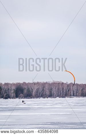 Kite Surfer Ride On Snowboard. Snowkiting In The Snow On Frozen Lake.