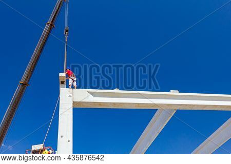 Mobile Crane Is Operating And Worker Is Assembly Concrete Joist In High Place. Height Worker Is Plac