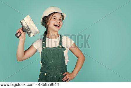 Home Renovation. Kid With Tool. Happy Small Construction Girl With Spatula. Teen Girl Use Putty Knif