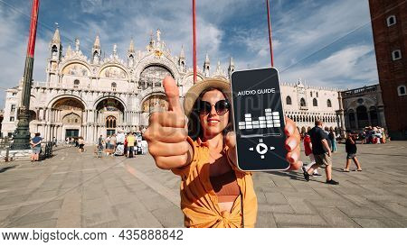 Audio Tour Online App On Digital Mobile Smartphone. Happy Young Student Woman Holding Phone Listenin